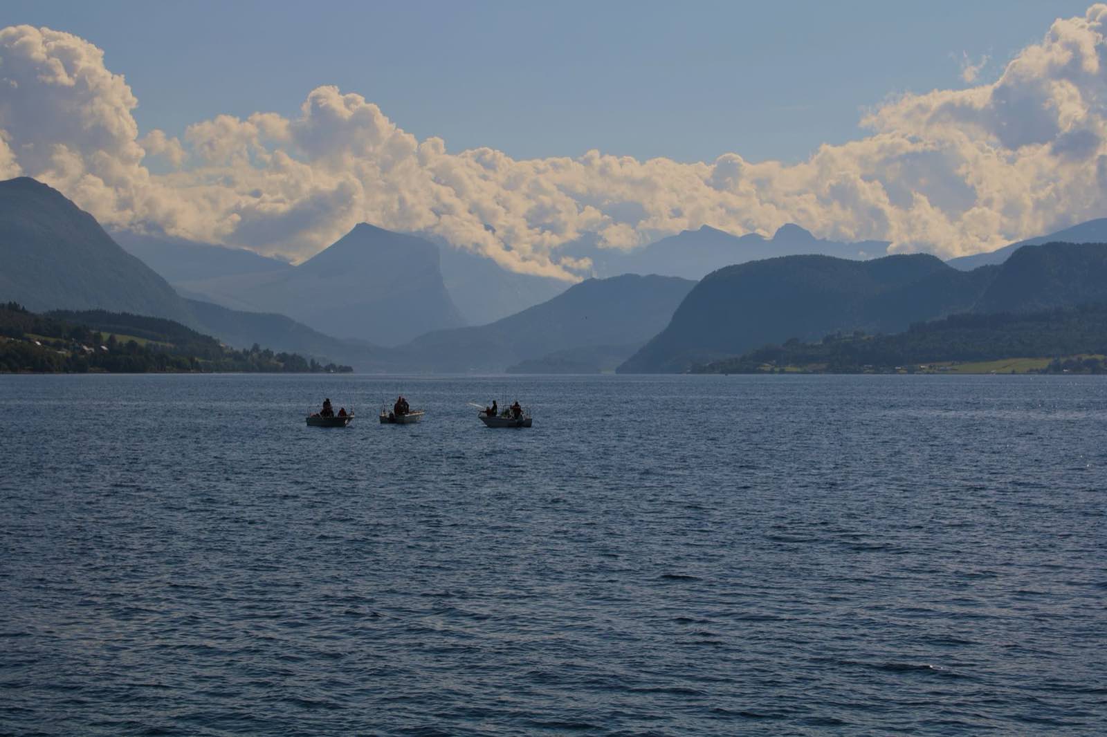 Small boats lying at anchor in a still fjord