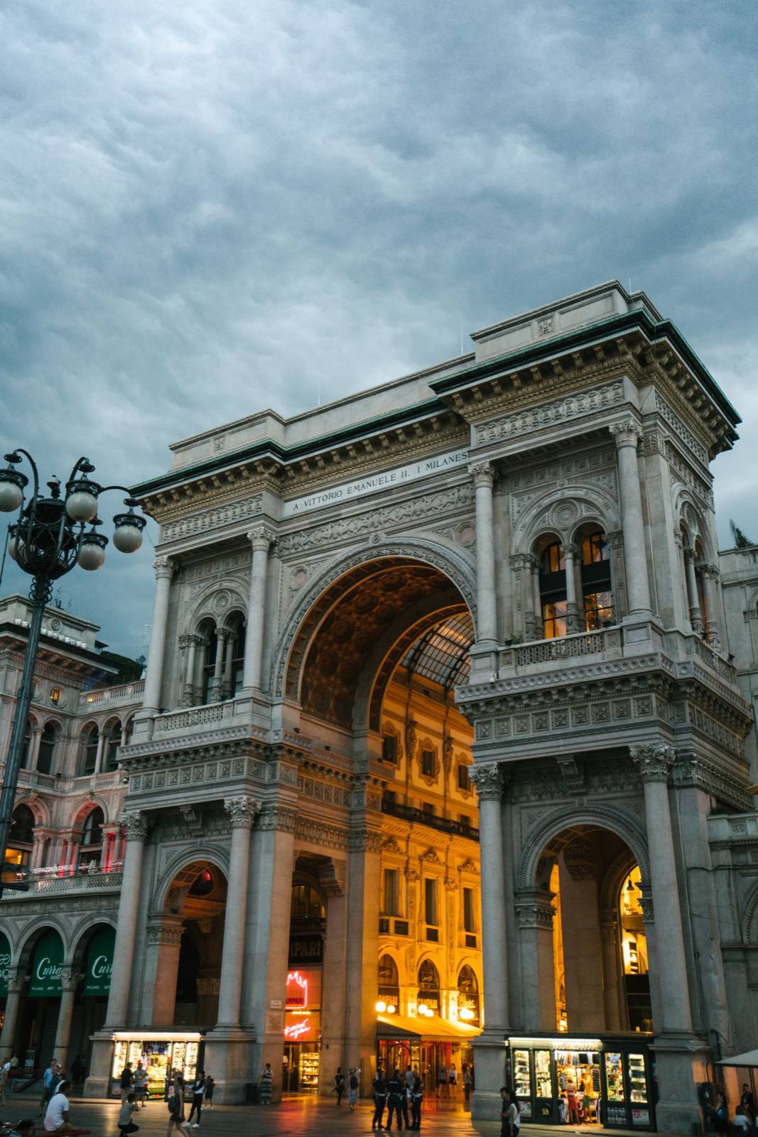The arch of a Milanese arcade under an evening sky